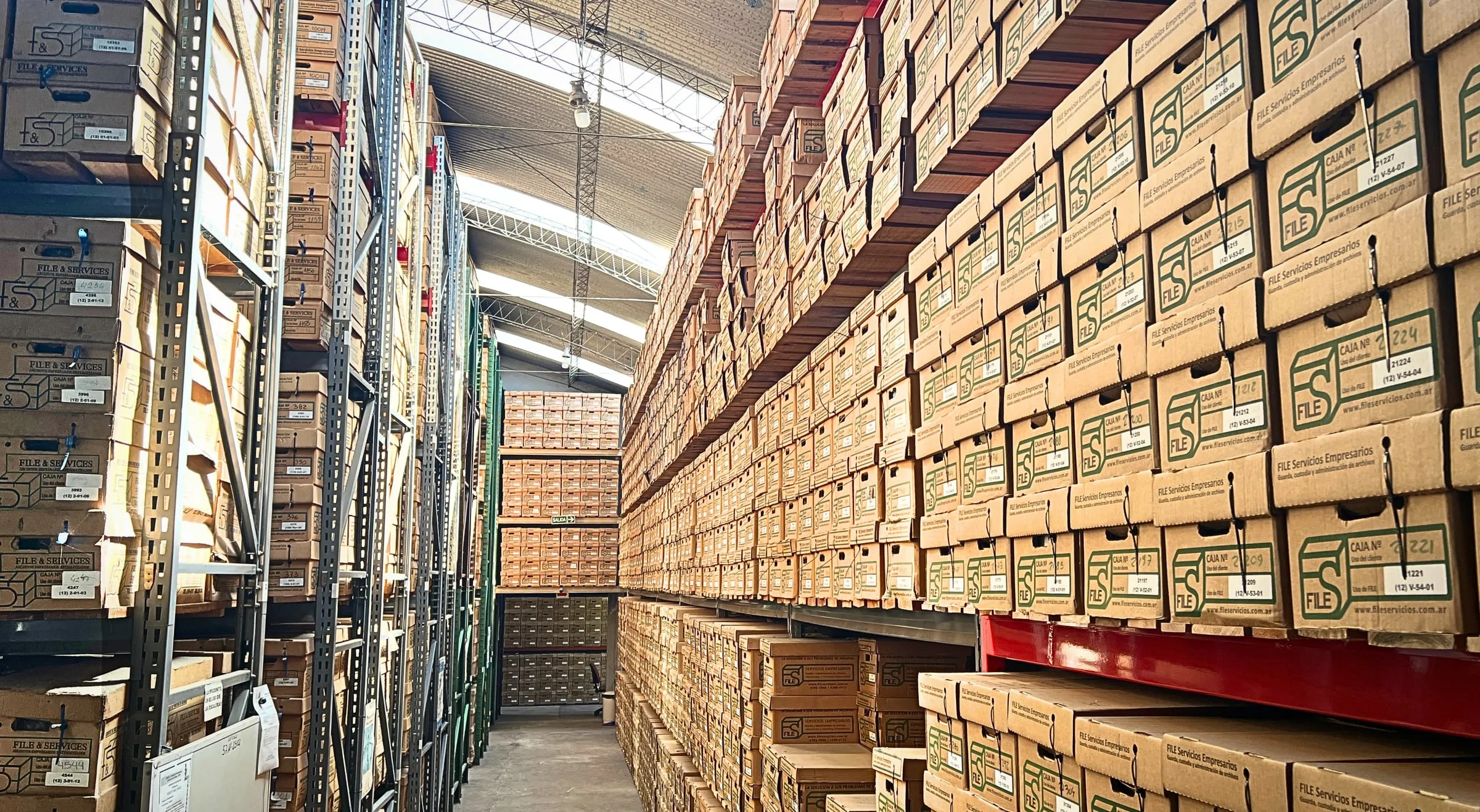 Pasillo del depósito con estanterías de cajas y buena iluminación